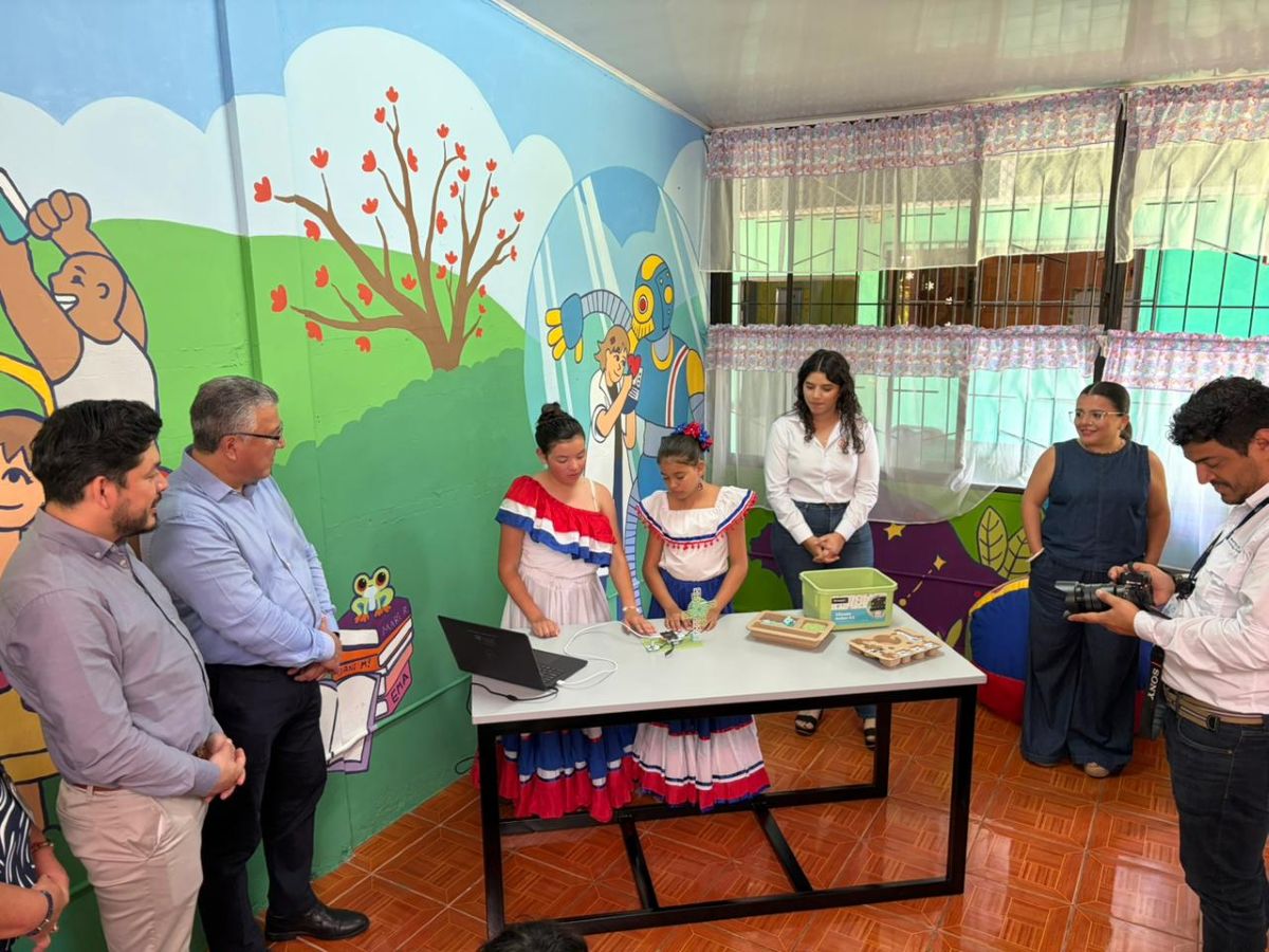 Leonardo Sánchez, ministro de Educación, y Carlos Araya, rector de la UCR, observan a niñas de la escuela realizando un ejercicio de robótica Fuente: UCR
